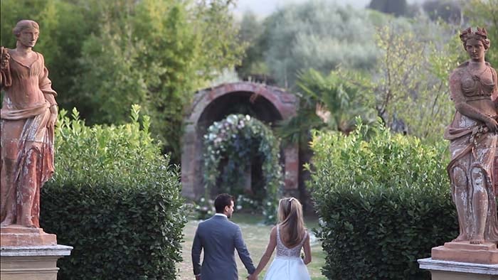 The bride and groom enter inside the Italian garden of Villa Catignano Siena Italy Villa Catignano wedding video in Siena - Villa Catignano Siena Italy